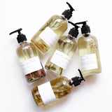 Several Among the Flowers botanical oil pump bottles laid out together from above