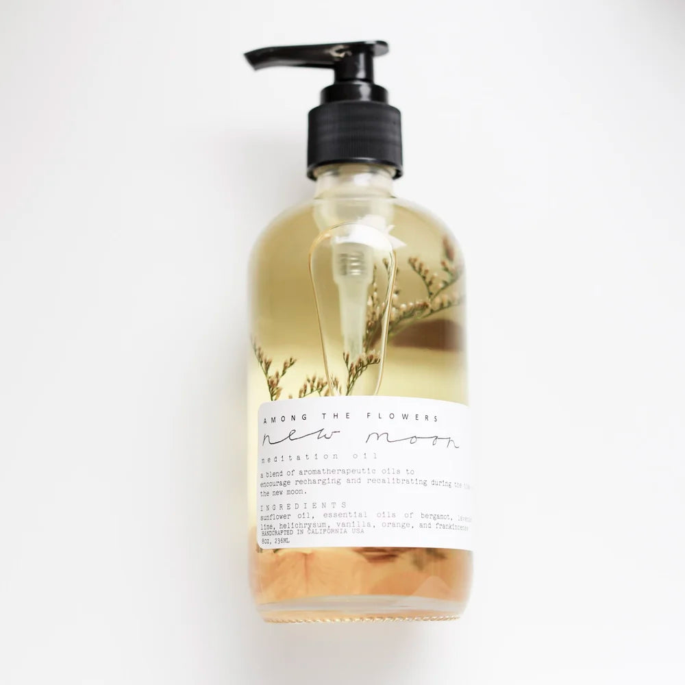 Among the Flowers New Moon Meditation Oil in a clear pump bottle with botanicals inside