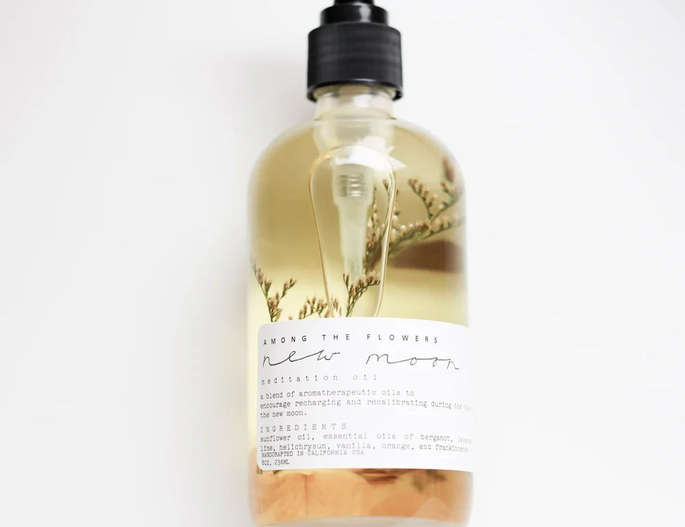 Among the Flowers New Moon Meditation Oil in a clear pump bottle with botanicals inside
