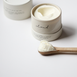 Among the Flowers Tallow Body Cream in an open white jar with a wooden spoon of cream