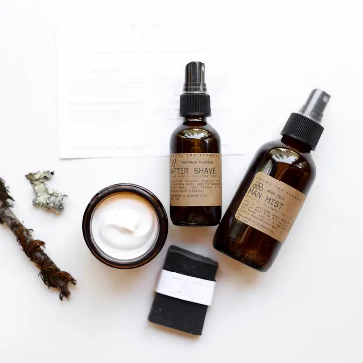 Among the Flowers Wild Man Kit contents laid out: after shave, mist, open balm jar and charcoal soap