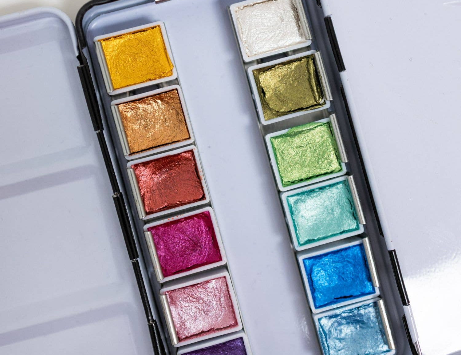 Bailey Rae Studio 12 Color Travel Metallic Watercolor Paint Palette, close-up of shimmering metallic pans in gold, green, pink, purple, blue and silver