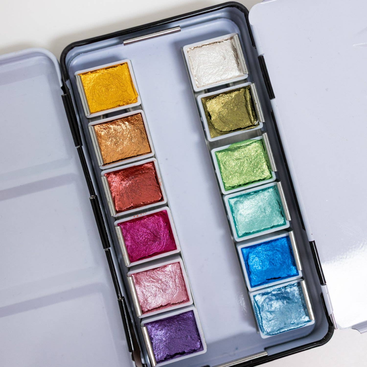 Bailey Rae Studio 12 Color Travel Metallic Watercolor Paint Palette, close-up of shimmering metallic pans in gold, green, pink, purple, blue and silver