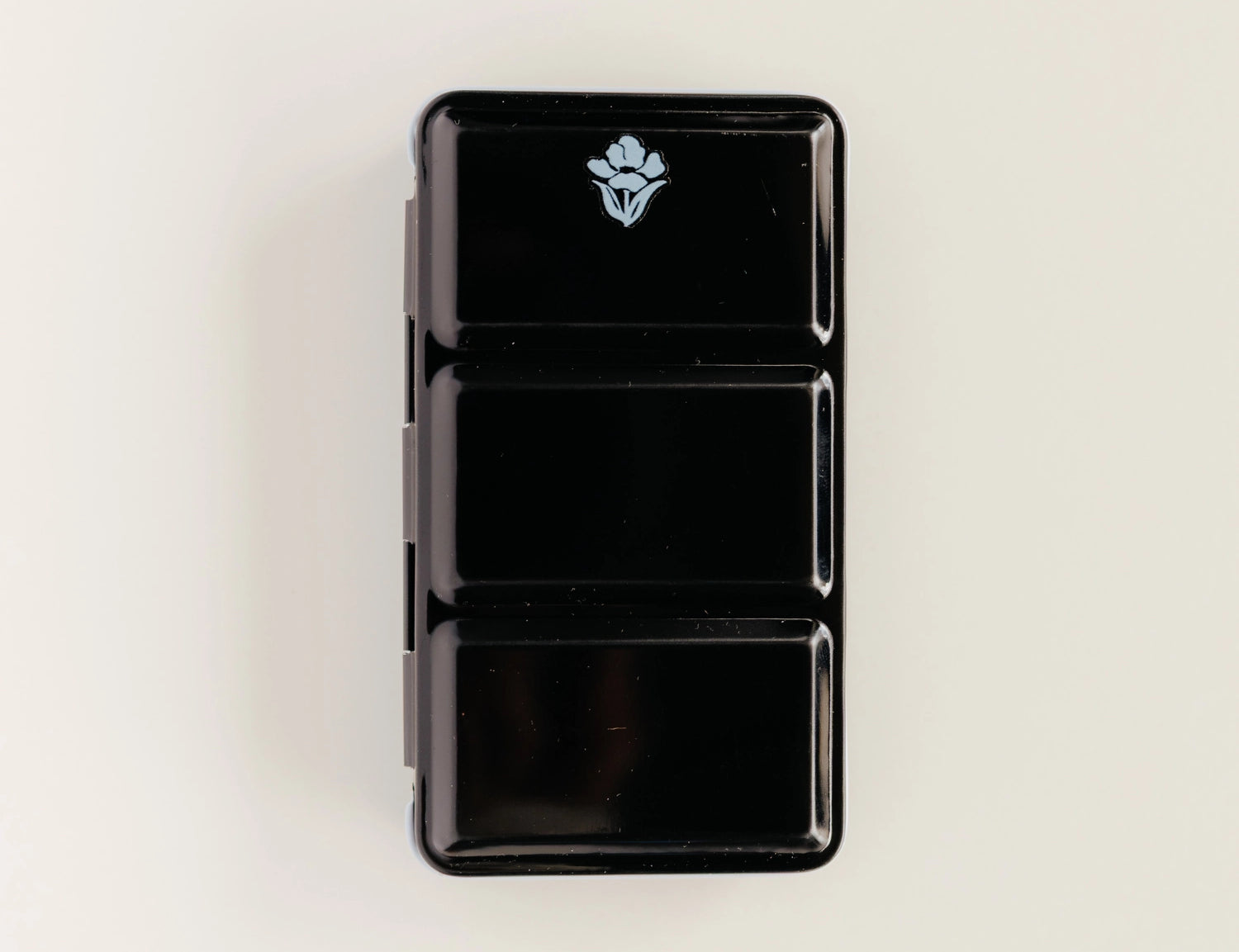 Bailey Rae Studio 12 Color Mini-Travel Paint Palette, closed black metal tin with a small logo, on a cream background