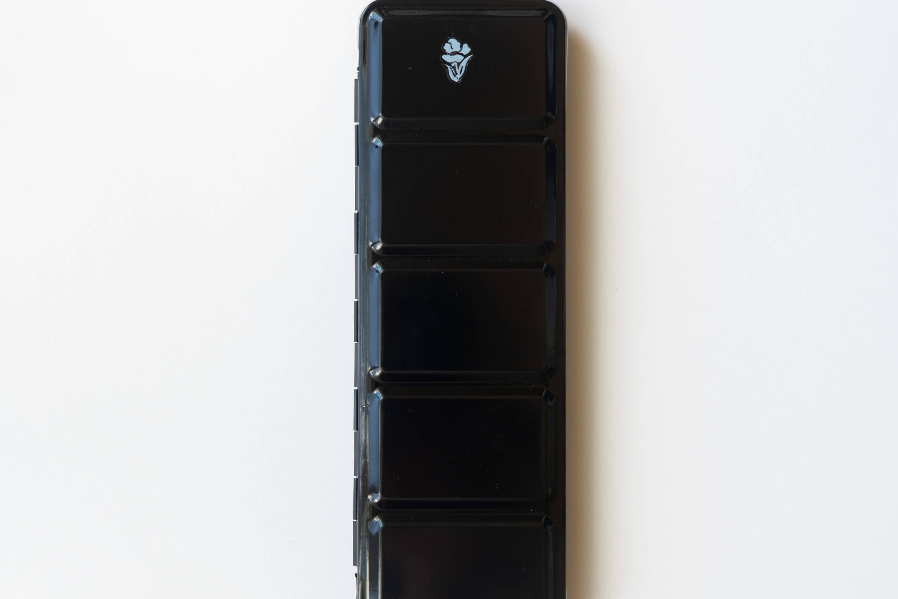 Bailey Rae Studio 24 Color Watercolor Paint Palette, closed black metal travel tin with a small logo, on white