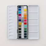 Bailey Rae Studio 24 Color Watercolor Paint Palette, open silver tin with two rows of twelve watercolor pans and a water brush, on white