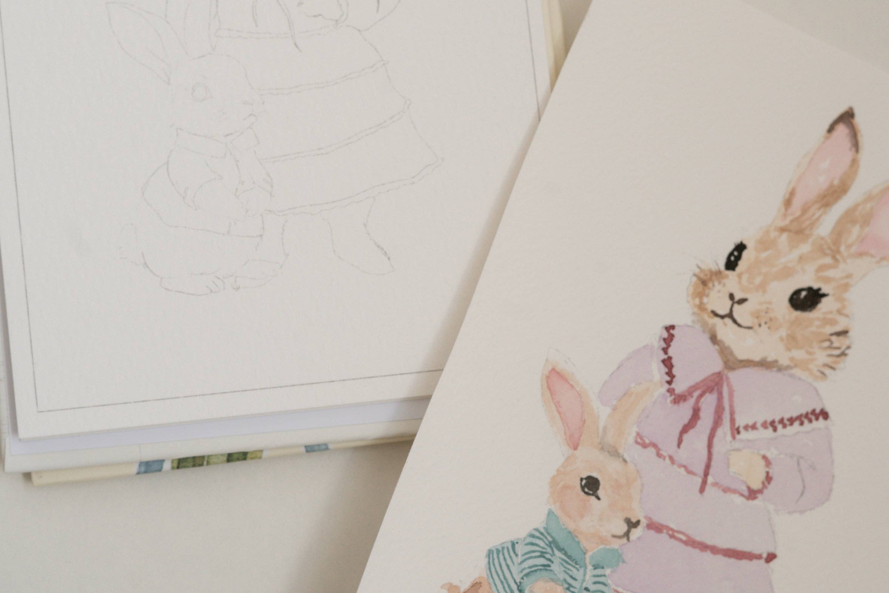 Bailey Rae Studio Mini A Little Bit of Spring Watercoloring Book, outline page beside a finished watercolor of a bunny in a pink dress