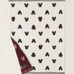 Barefoot Dreams Classic Disney Baby Blanket with a corner turned up to show the burgundy reverse side