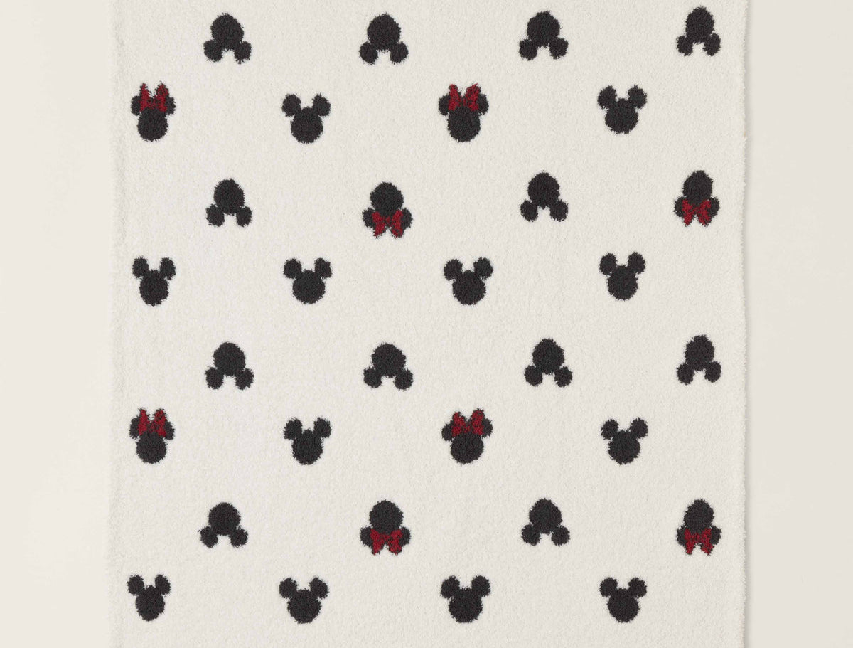 Barefoot Dreams Classic Disney Baby Blanket, a cream blanket with black Mickey and red-bow Minnie icons