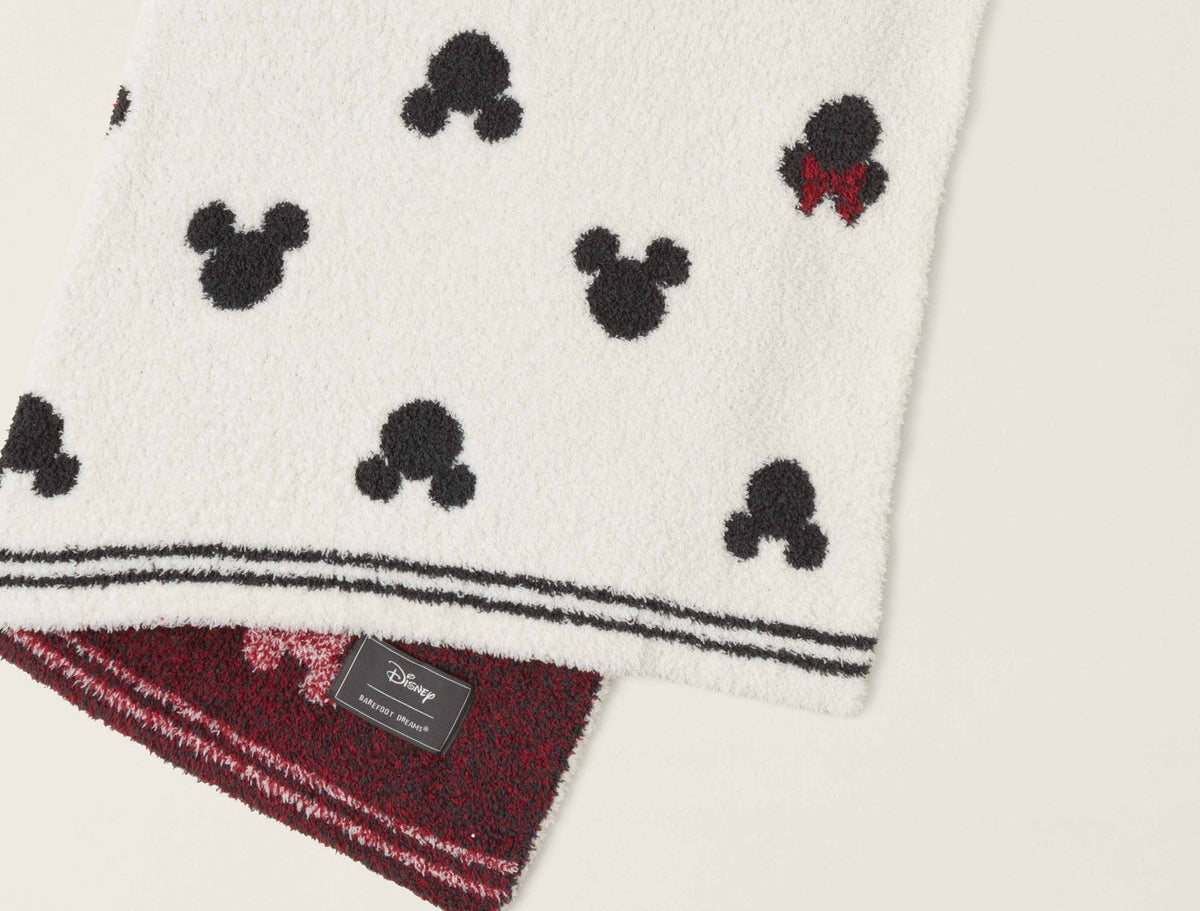 Barefoot Dreams Classic Disney Baby Blanket draped to show the Mickey print and burgundy underside