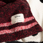 Close-up of the Disney and Barefoot Dreams label on the burgundy striped side of the Classic Disney Baby Blanket