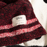 Close-up of the Disney and Barefoot Dreams label on the burgundy striped side of the Classic Disney Baby Blanket