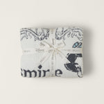 Barefoot Dreams Cozy Disney Princess Blanket in Jasmine folded and tied with a Disney ribbon