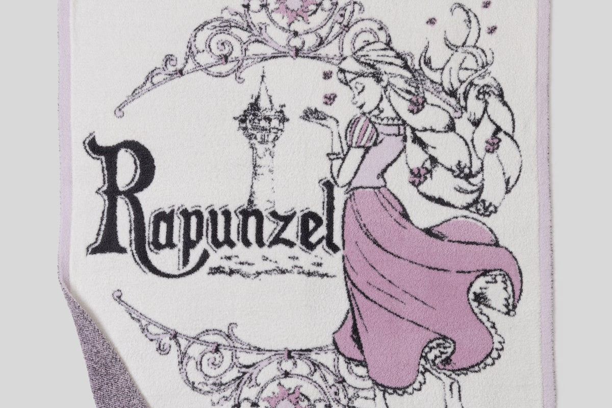 Close-up of the Rapunzel lettering and purple gown knit on the Barefoot Dreams Cozy Disney Princess Blanket