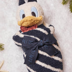 Barefoot Dreams Disney Blanket Buddie in Donald Duck rolled and tied with a ribbon on a snowy background