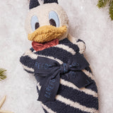 Barefoot Dreams Disney Blanket Buddie in Donald Duck rolled and tied with a ribbon on a snowy background