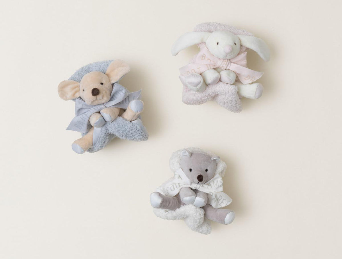 Barefoot Dreams Disney Blanket Buddies in Blue Puppy, Pink Bunny and a gray bear laid out together