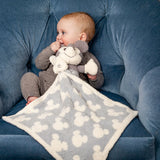 Baby in a blue chair cuddling the Barefoot Dreams Disney Blanket Buddie in Vintage Mickey Mouse