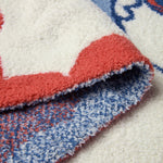 Close-up of the red and blue knit edge on the Barefoot Dreams Disney Stroller Blanket in Minnie Love