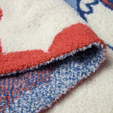Close-up of the red and blue knit edge on the Barefoot Dreams Disney Stroller Blanket in Minnie Love