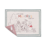 Barefoot Dreams Disney Stroller Blanket in Winnie the Pooh with a corner turned to show the pink reverse