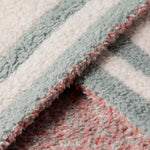 Close-up of the sage and pink knit edge on the Barefoot Dreams Disney Stroller Blanket in Winnie the Pooh