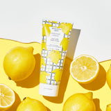 Beekman 1802 2oz Hand Cream in Sunshine Lemon surrounded by lemon halves on yellow