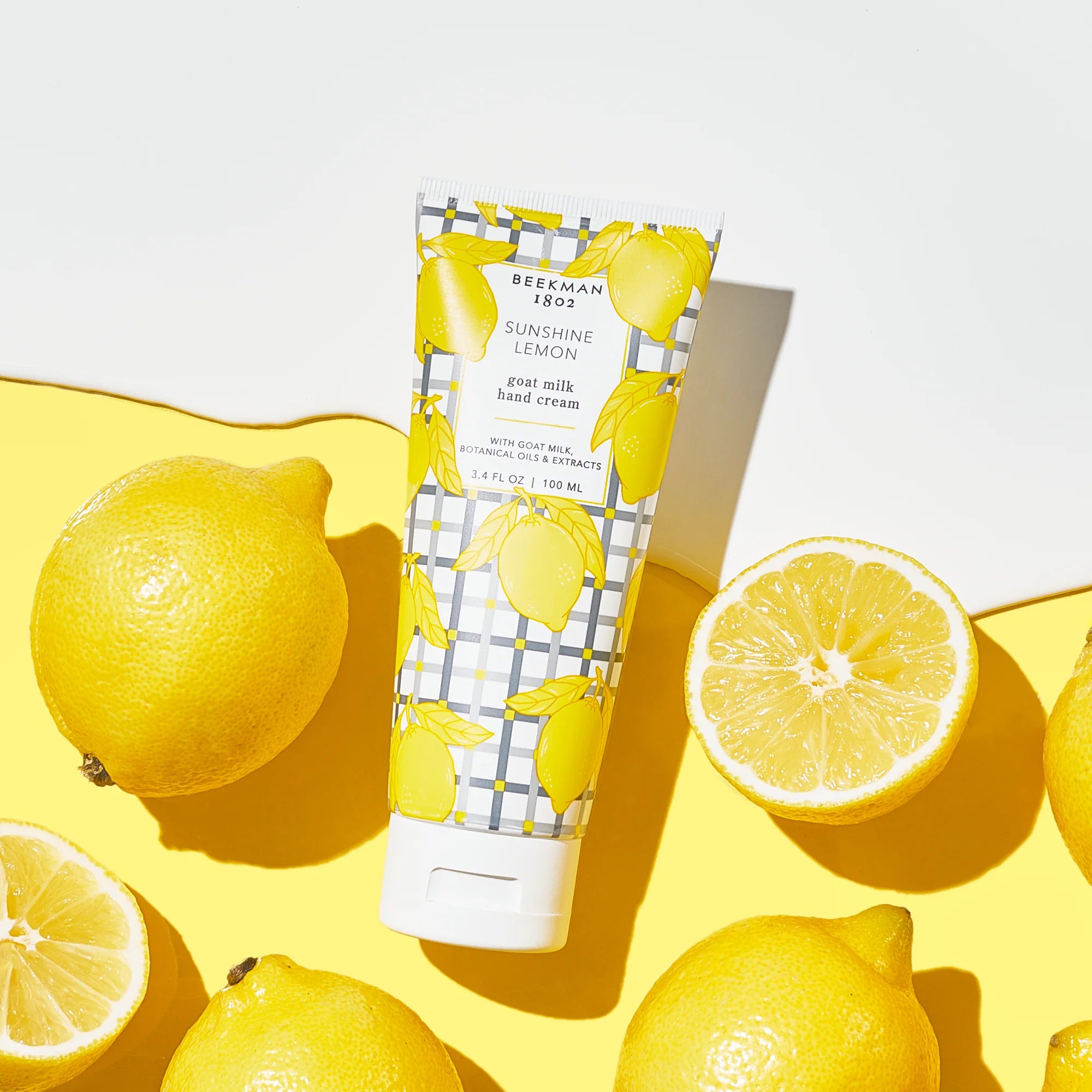 Beekman 1802 2oz Hand Cream in Sunshine Lemon surrounded by lemon halves on yellow