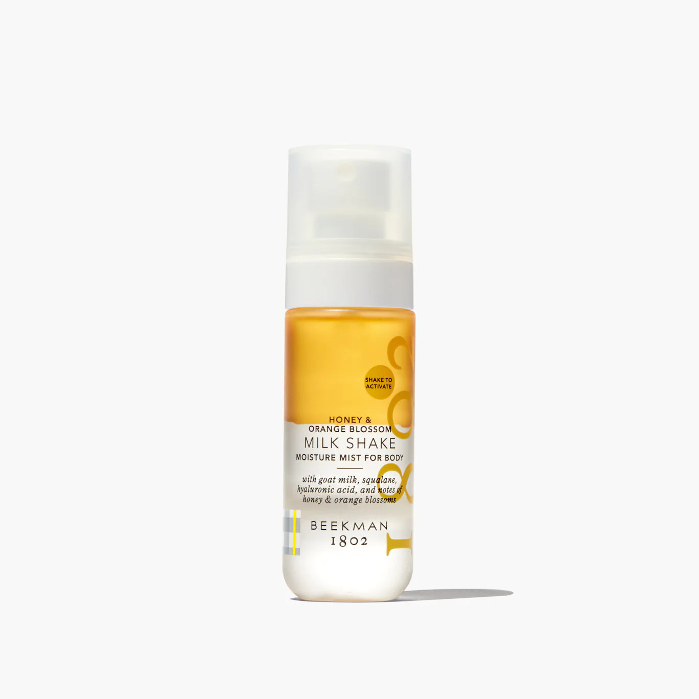 Beekman 1802 Milk Shake Moisture Mist in Honey & Orange Blossom, a golden bi-phase body mist in a clear spray bottle