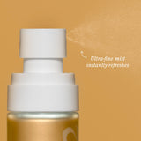 Close-up of the Beekman 1802 Milk Shake Moisture Mist spray nozzle releasing an ultra-fine mist