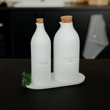 Blomus Bon Appetit Porcelain Cruet Bottles on their white tray with a sprig of parsley in a dark kitchen