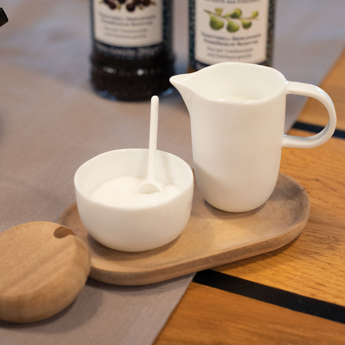 Blomus Cream and Sugar Service Tray on a wooden table with the sugar bowl open and a spoon