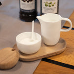 Blomus Cream and Sugar Service Tray on a wooden table with the sugar bowl open and a spoon