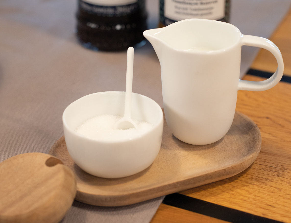 Blomus Cream and Sugar Service Tray on a wooden table with the sugar bowl open and a spoon