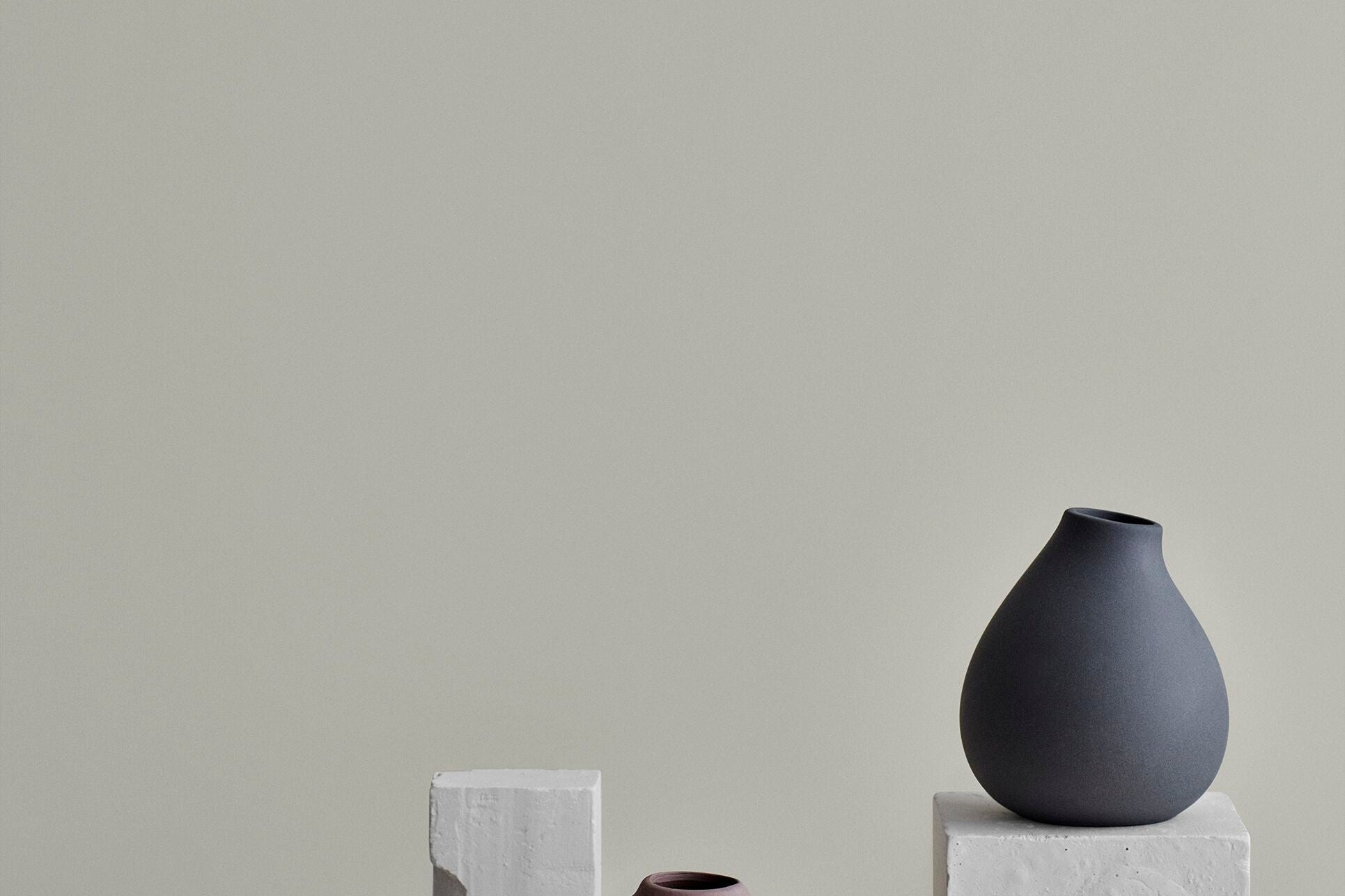 Blomus Nona 3 Vase Set displayed on stone blocks against a gray wall