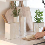 Blomus Porcelain Bag Vases holding herbs on a kitchen counter with cutting boards