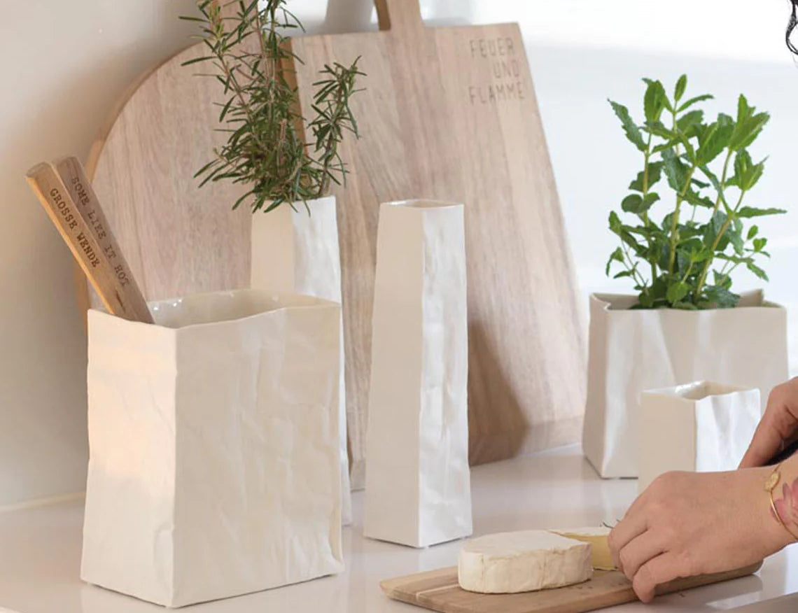 Blomus Porcelain Bag Vases holding herbs on a kitchen counter with cutting boards