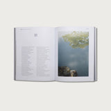 Book of Proverbs KJV hardcover open to chapter 18 with a photo of trees reflected in water