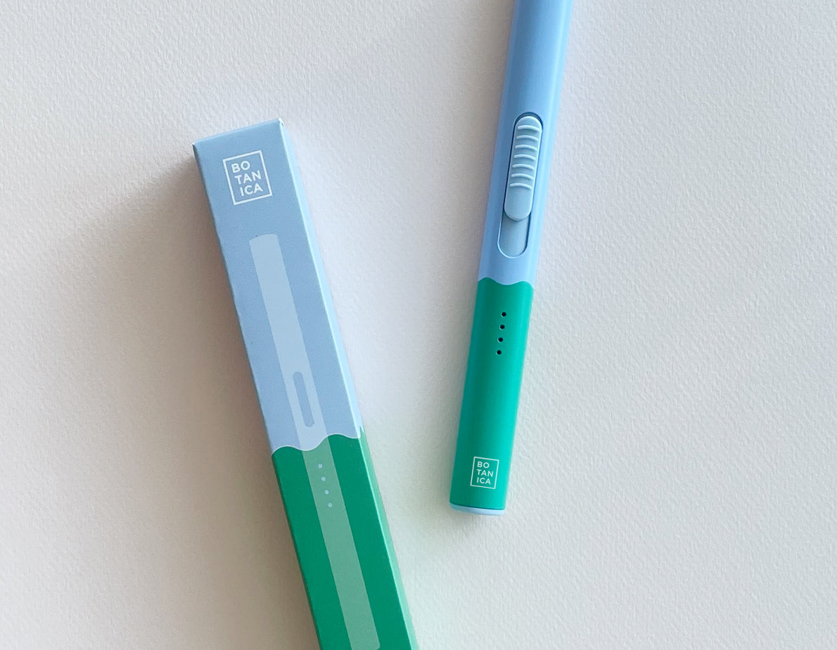 Botanica Flameless Lighter in Earth, a sky blue and green USB lighter beside its box