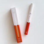 Botanica Flameless Lighter in Poppy, a white and red USB lighter beside its box