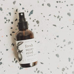 Broken Top Brands Fresh Squeezed Linen Spray bottle lying on a terrazzo surface