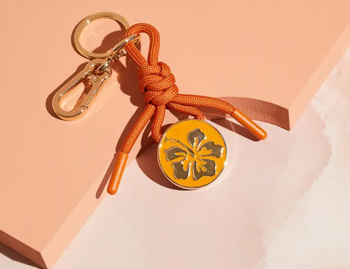Cai & Jo Bag Charm Keychain, hibiscus enamel charm on an orange knotted cord with a gold clasp
