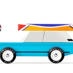 Candylab Toys Cotswold Wooden Royal Toy, a blue wooden station wagon with a colorful surfboard on the roof, side view