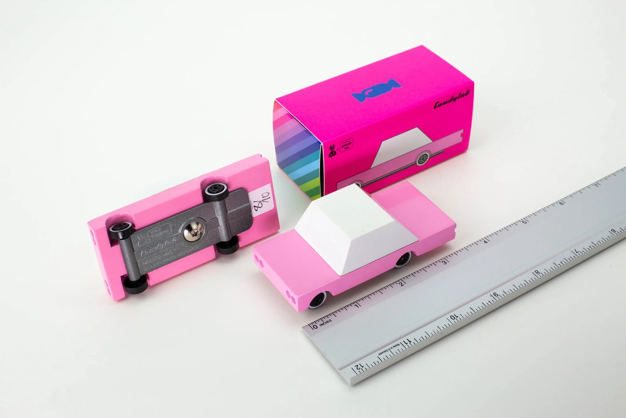 Candylab Toys Pink Wooden Sedan beside its hot pink retail box and a ruler for scale