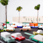 Candylab Toys Sheriff Truck in a toy parking lot with other wooden cars and palm trees