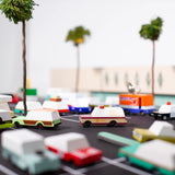 Candylab Toys Sheriff Truck in a toy parking lot with other wooden cars and palm trees