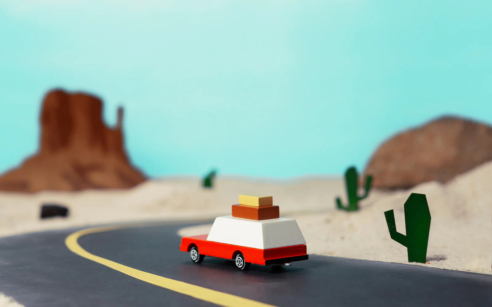 Candylab Toys Wooden Luggage Wagon on a toy desert road with cacti