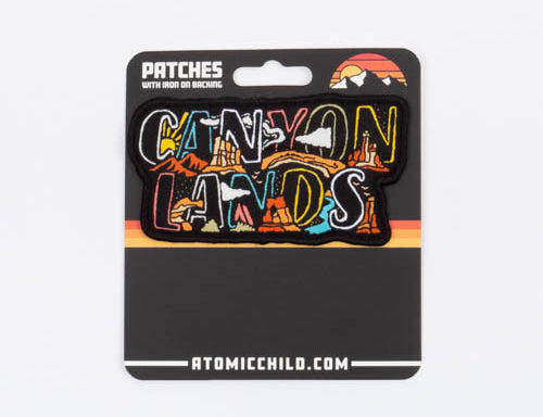 The Canyonlands nameplate patch on its Atomic Child backer card, marked patches, iron on or sew on.