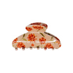 Classic claw clip in Brushed Sand Floral, a glossy light beige hair claw clip with an orange and red floral print, on a white background.
