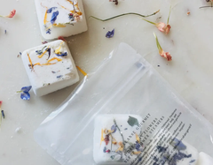 Cleanse Gourmet I Dream In Flowers Sleep Shower Steamers, white cubes with dried flower petals in a clear pouch